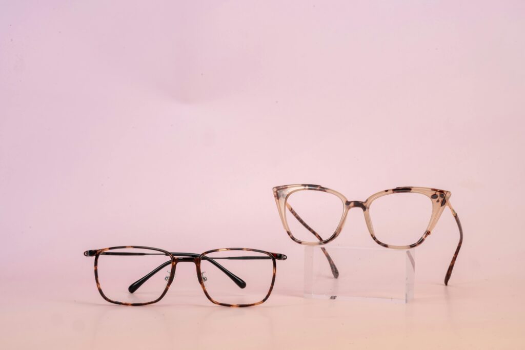 Two stylish glasses on a pink background for modern eyewear fashion.